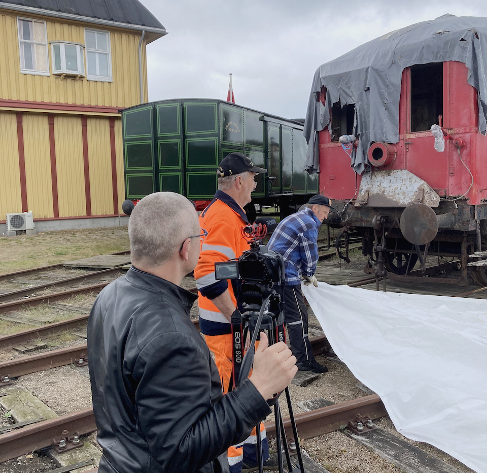 Ein Kameramann filmt im Eisenbahnmuseum Gedser einen historischen Triebwagen.