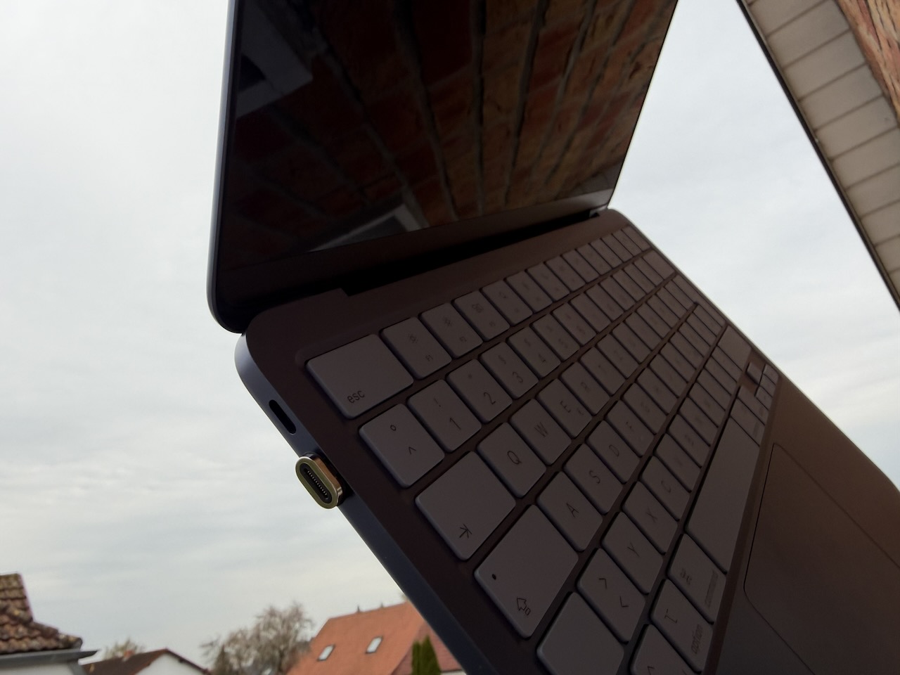 MacBook Neo mit einem magnetischen Adapter für das Ladekabel